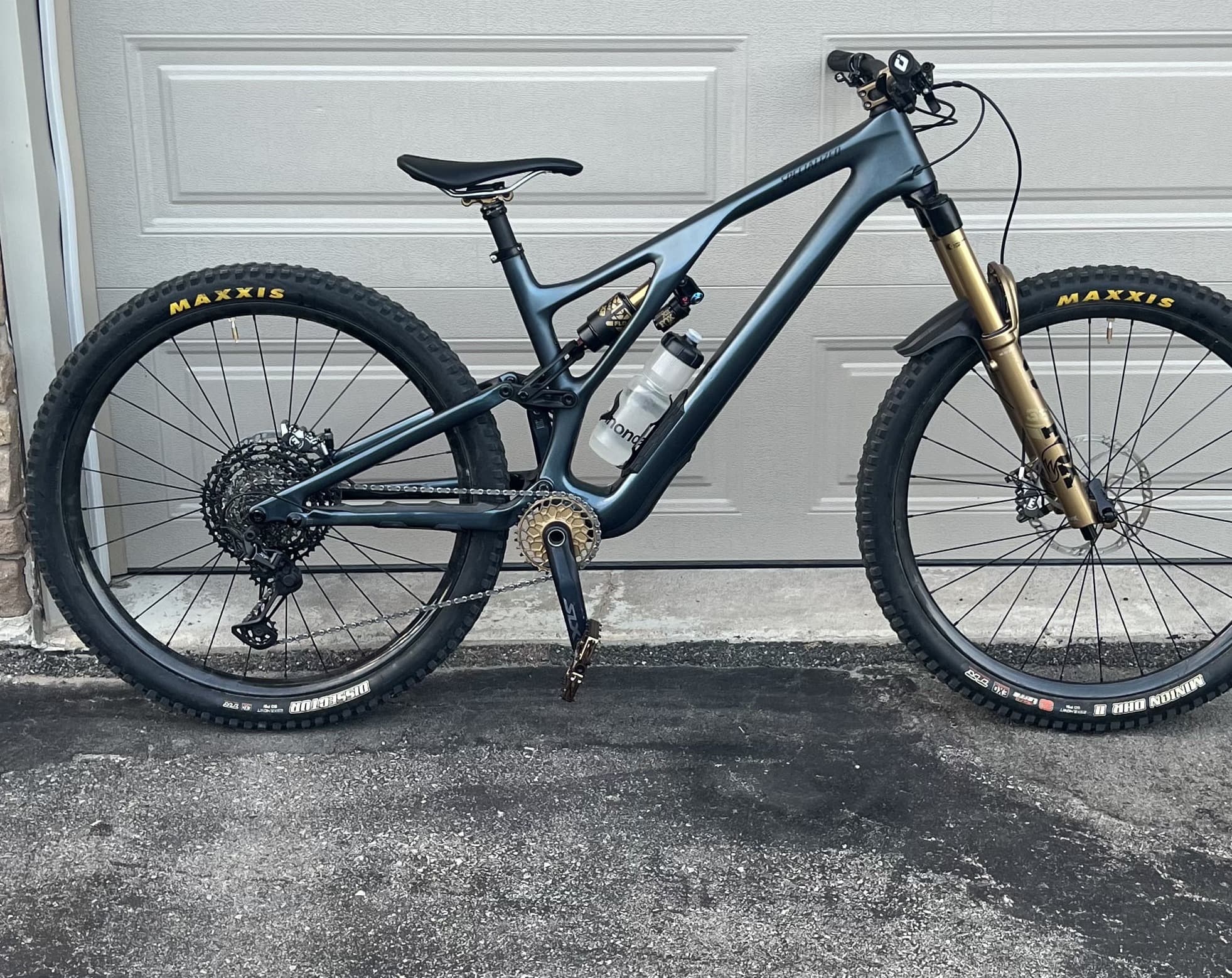 Full-suspension mountain bike leaning against a garage door